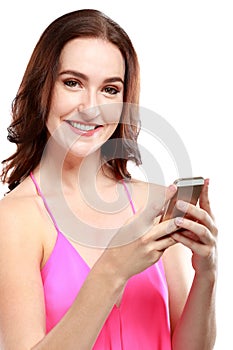 Attractive woman smiling while holding a mobilephone