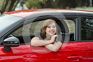 Attractive woman smiling proud sitting at driver seat holding and showing car key in new automobile buying and renting