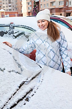 Attractive woman and snowy car with drawing heart shape