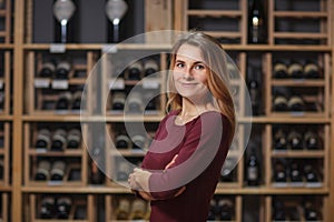 Attractive woman sommelier in wine cellar background