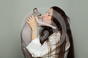 Attractive woman and sphinx cat pet on gray background