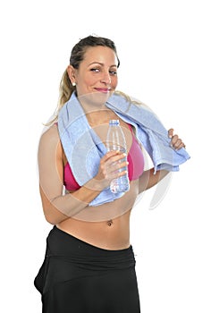 Attractive and woman in sport clothes with towel drinking water bottle at gym workout