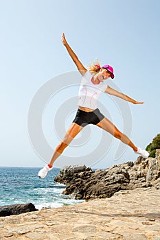 Attractive woman in sportswear jumping outdoors.