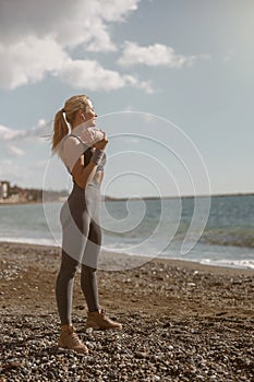 Attractive woman in sportswear training on beach