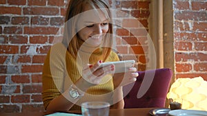 Attractive woman in a street cafe reading a text message from her phone