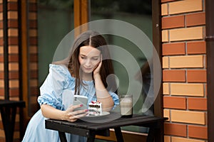 Attractive woman in a street cafe reading a text message from her phone. vacation Europe. italian lifestyle and travel