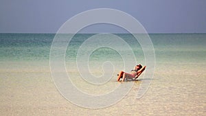 attractive woman sunbathing in gorgeous crystal water,cambodia