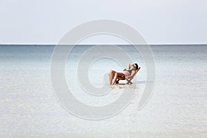 attractive woman sunbathing in gorgeous crystal water, cambodia