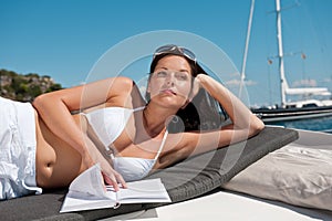 Attractive woman sunbathing on luxury boat