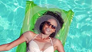 Attractive woman with sunglasses relaxing on lilo