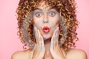 Attractive woman Surprised look and narrow lips of the hand near the face curly hair