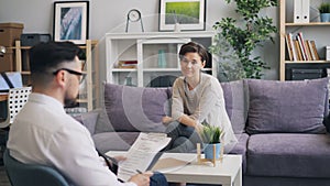 Attractive woman talking to therapist in office discussing personal problems