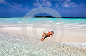 Attractive woman is tanning on a sandbank