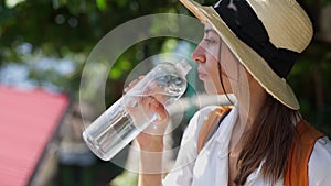 Attractive woman thirsty from heat and drinks water