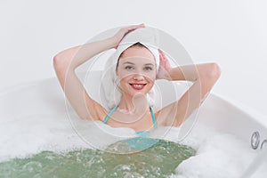 attractive woman with towel on head relaxing in bath