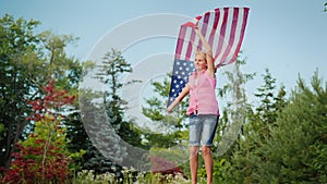 Attractive woman with the US flag jumping on a trampoline in her backyard