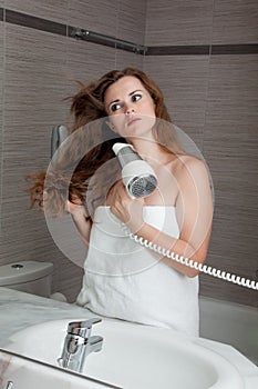 Attractive woman using fen in bathroom photo