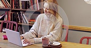 Attractive woman using laptop in library