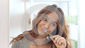 Attractive woman using toothbrush and toothpaste for brush teeth in bathroom