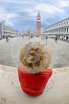 Attractive woman in Venice sitting at st. Mark`s square and enjoying the scene photo
