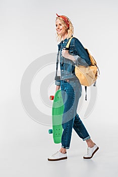 attractive woman walking with bag and skateboard