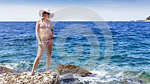 Attractive woman walking on the shore of the Mediterranean Sea.