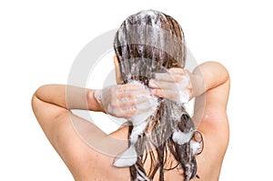 Attractive woman washing hair with shampoo in shower