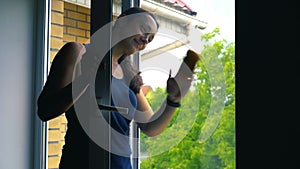 Attractive Woman Washing the Window. Cleaning Company worker working. Young woman washing window, close up. Cute girl with