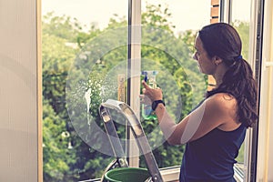 Attractive Woman Washing the Window. Cleaning Company worker working. Young woman washing window, close up. Cute girl with