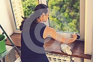 Attractive Woman Washing the Window. Cleaning Company worker working. Young woman washing window, close up. Cute girl with