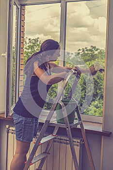 Attractive Woman Washing the Window. Cleaning Company worker working. Young woman washing window, close up. Cute girl with