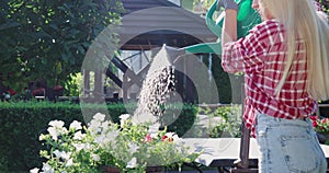 Attractive woman watering flowers at garden