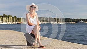 An attractive woman wearing a summer hat on the beach.