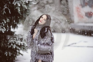 Attractive woman in white and gray fur coat