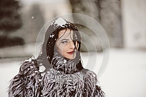 Attractive woman in white and gray fur coat