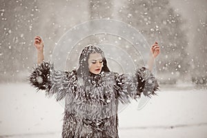 Attractive woman in white and gray fur coat