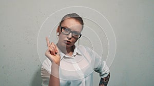 Attractive woman in white shirt, with ear expanders shaking finger with rebuke