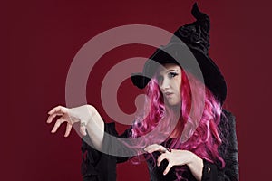 Attractive woman in witches hat and costume with red hair. Halloween