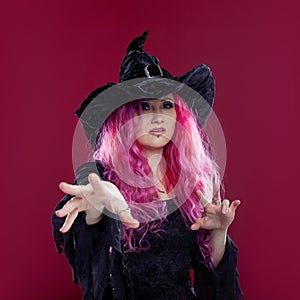 Attractive woman in witches hat and costume with red hair. Halloween