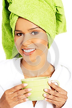 Attractive woman wrapped in towel with turban on head, holding a