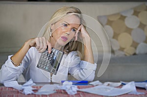 attractive worried and desperate blond woman calculating domestic money expenses doing paperwork and bank bills accounting