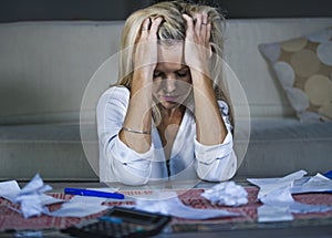 attractive worried and desperate blond woman calculating domestic money expenses doing paperwork and bank bills accounting