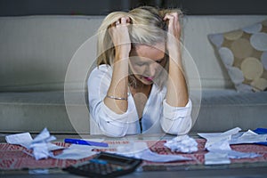 attractive worried and desperate blond woman calculating domestic money expenses doing paperwork and bank bills accounting