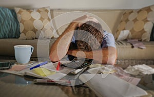 Attractive worried stressed man at home calculating month tax expenses with calculator accounting payments doing bank paperwork in