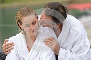 attractive youg couple in white bath-robes on terrace