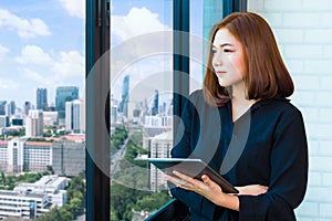 Attractive yound businesswoman holding computer tablet and deep