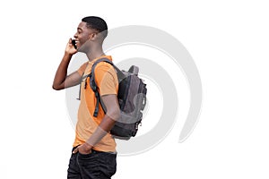 Attractive young african american man walking and talking on mobile phone by white background