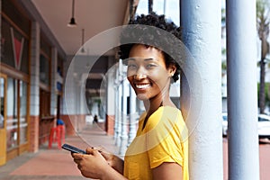 Attractive young african woman holding a mobile phone