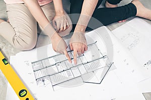 Attractive young asian adult couple looking at house plans.