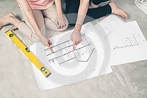 Attractive young asian adult couple looking at house plans.